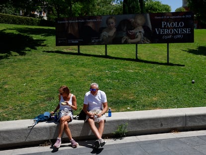 Unos turistas descansan este jueves al sol junto al Museo del Prado de Madrid.