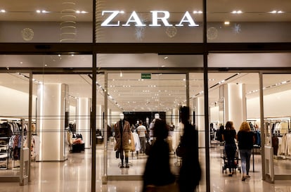 Unos compradores pasan por delante de una tienda de ropa Zara, del grupo español Inditex en diciembre de 2022.
