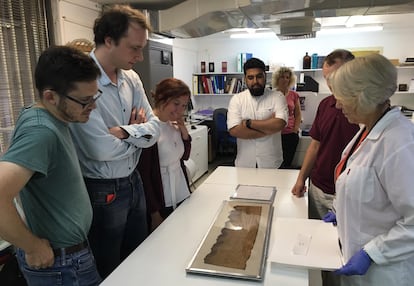 Part of the team from the Bernoulli Institute for Artificial Intelligence observes one of the Dead Sea Scrolls. They trained their system with digitized copies of 25 of them.