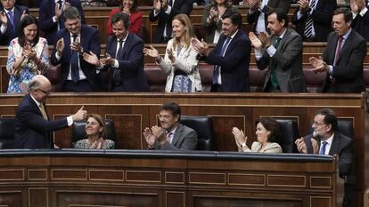 Deputies with Spain's ruling Popular Party applaud following the budget vote.