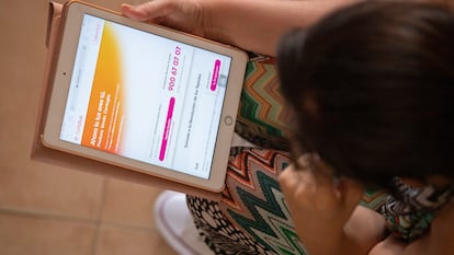 Una mujer consulta en una tablet la web de Holaluz.