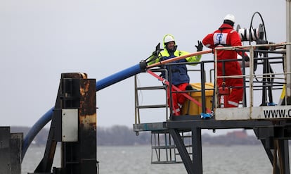 Workers deploy a submarine fiber optic cable between the German islands of Rügen and Hiddensee