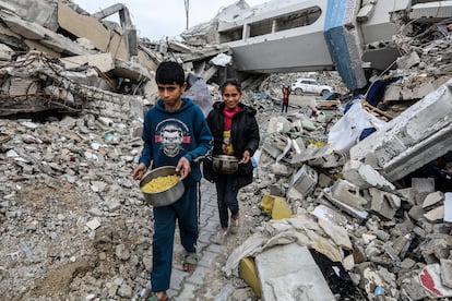 Dos niños reciben comida distribuidos por voluntarios en Rafah (Gaza), este viernes.