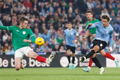Pacheco (i) se lanza ante el jugador de Uruguay, Agustían Canobbio, durante el amistoso.