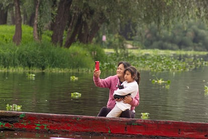 A mother and daughter wait for the passage of the relic of St. Jude on a raft in Xochimilco.