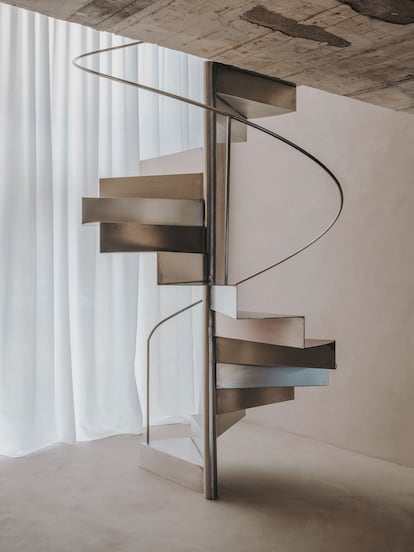 Un gran elemento que estructura la casa es la escalera de caracol fabricada de una sola pieza en inox pulido satinado.